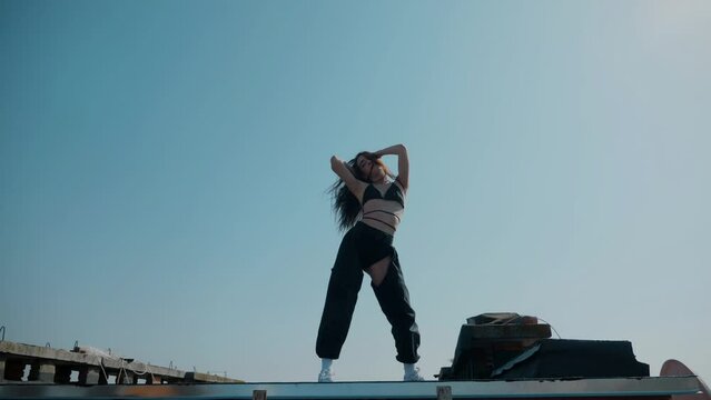 A girl in a swimsuit dances sexy on the roof. booty dance, booty shake, Twerk, High Heels, Hip Hop. Beautiful female dancer. Twerking