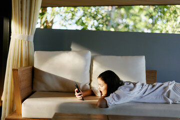 Young woman home smartphone bed mobile female phone