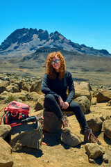 Fototapeta premium tourist girl is sitting against the background of mountains