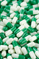 Zoom frame pharmaceuticals green white capsules. Pills and drugs. Pharmaceutical Industry