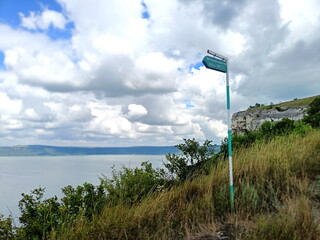 View from the slope of the hill covered with abundant green vegetation on the wide channel of the Dniester under snow-white summer clouds.