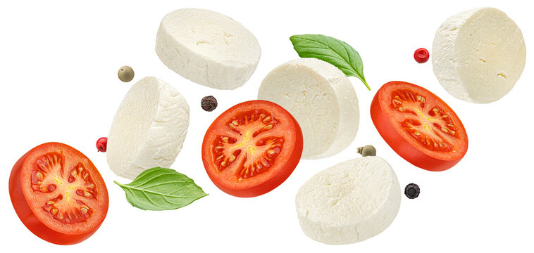 Falling mozzarella cheese and tomato slices with basil leaves isolated on white background