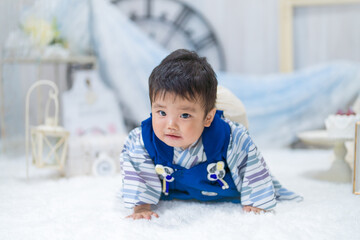 バースデーフォトセットで1歳の誕生日に一生餅を背負ってハイハイするつらそうな表情の赤ちゃん