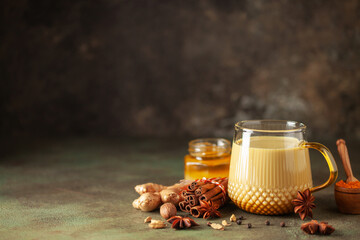 Golden Cinnamon  Turmeric Milk. Trendy hot Healthy drink with turmeric roots and spices. Indian Masala Haldi Doodh. - obrazy, fototapety, plakaty