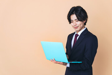 オートパソコンを使うスーツを着た若い男性　ビジネスマン