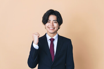 ガッツポーズするスーツを着た若い男性　ビジネスマン