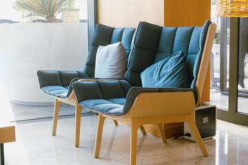 Wooden chairs with blue fabric upholstery in the hotel lobby. Places to wait or rest. Modern furniture made from environmentally friendly materials.