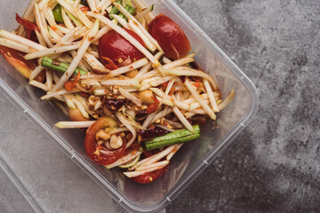 Thai spicy papaya salad in box, international Thai food Known and popular, made with papaya and tomatoes, it tastes sour, sweet and spicy.