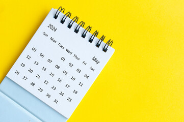 May 2024 table calendar on yellow cover background with customizable space for text.