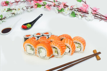 sushi set, a lot of rolls, sakura branch and chopsticks, on a white isolated background © Kurganskiy