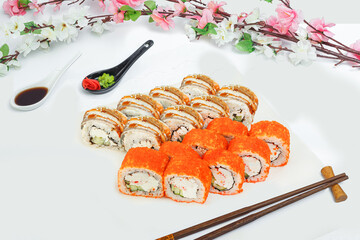 sushi set, a lot of rolls, sakura branch and chopsticks, on a white isolated background © Kurganskiy