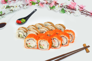 sushi set, a lot of rolls, sakura branch and chopsticks, on a white isolated background © Kurganskiy