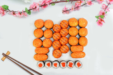 sushi set, a lot of rolls, sakura branch and chopsticks, on a white isolated background © Kurganskiy