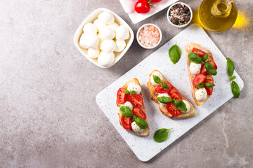 Tomato, basil and mozzarella cheese fresh made caprese bruschetta. Italian tapas, antipasti with vegetables, herbs and oil on grilled ciabatta and baguette bread. Open sandwich.
