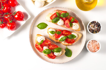 Tomato, basil and mozzarella cheese fresh made caprese bruschetta. Italian tapas, antipasti with vegetables, herbs and oil on grilled ciabatta and baguette bread. Open sandwich. - obrazy, fototapety, plakaty