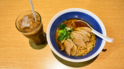 Clear soup ramen with delicious meat pieces in a ceramic bowl​  and expresso iced coffee