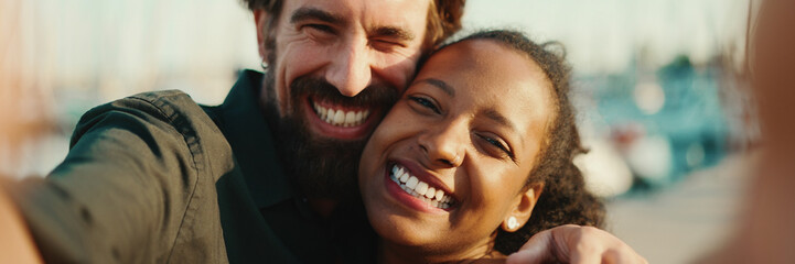 Close up portrait of happy man and smiling woman doing stream on smartphone. Close-up, joyful young interracial couple communicating via video call using mobile phone - Powered by Adobe