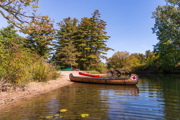 voyaguer canoe on shore with a smaller 16 foot prospector style canoe  in background shot on the toronto islands in autumn