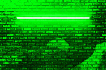 green neon light bulb on brick wall. Background texture of empty old  brick wall with glowing green neon lamps.