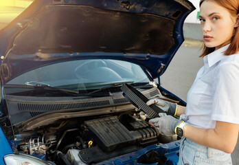 female motorist with a timing belt in her hands, concept of timing belt replacement and service