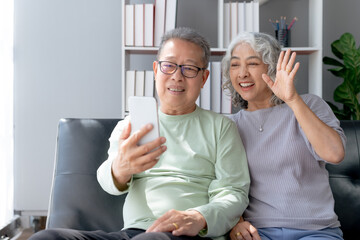 Happy Asian senior couple having a video call on the phone.