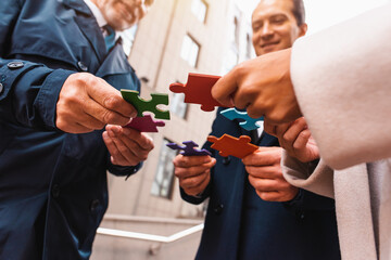 Businessmen working together to build a puzzle as teamwork, partnership and integration concept