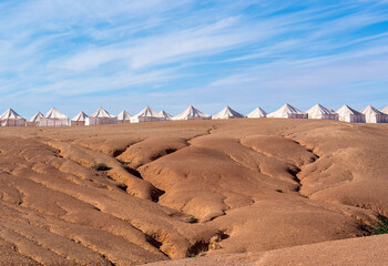 Morocco, desertic landscape in Agafay near Marrakech. 
Tents from the desert Camp in the background