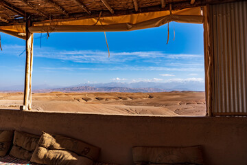 Morocco, desertic landscape in Agafay near Marrakech. View from inside out the Camp. Atlas mountain in the background.