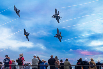 Fototapeta na wymiar Fighter jets flying over spectators on a pier