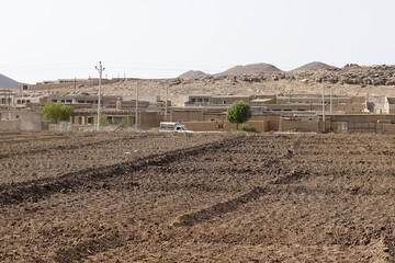 A rural village in northern Sudan between an agricultural field and the mountains