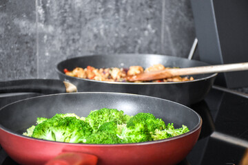 Steaming broccoli in a red pan cooking in the kitchen