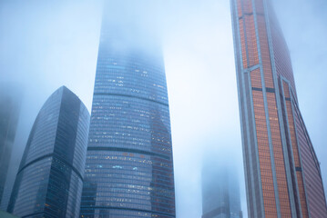 Skyscrapers rise into the foggy cloudy sky. Moscow City.