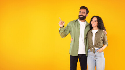 Arab Man Hugging Lady Pointing Showing Copy Space, Yellow Background