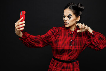 Young woman with Halloween makeup face art mask wear clown costume red dress do selfie shot on...