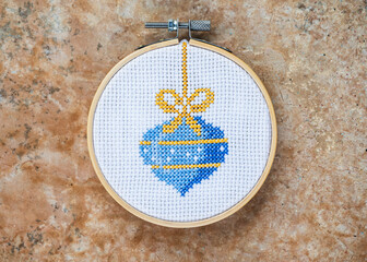 Details of handmade cross-stitch and wooden decoration for Christmas.