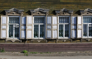 Wooden elements of window decoration. Windows in an old wooden house. The wall of the European house.