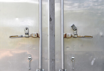 back door of delivery truck, gray aluminum cargo container door with steel latch, shipping...