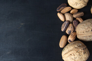 Pine nuts and walnuts close-up on a dark background.
