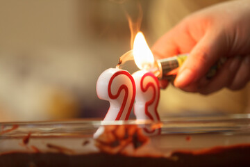 Encendiendo las velas de celebración en el 23 aniversario - obrazy, fototapety, plakaty