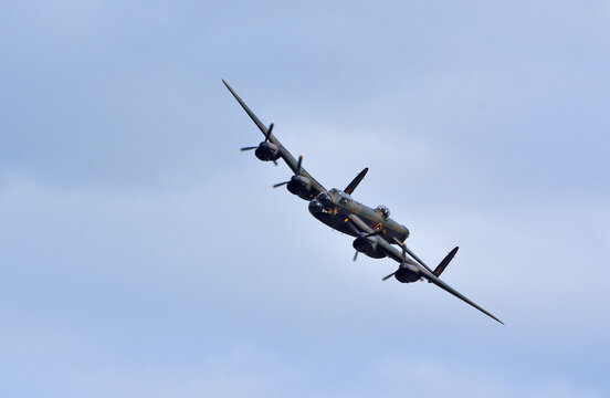ICKWELL, BEDFORDSHIRE, ENGLAND - JULY 04, 2023; Vintage Avro Lancaster world war 2 bomber with wheels down in flight.