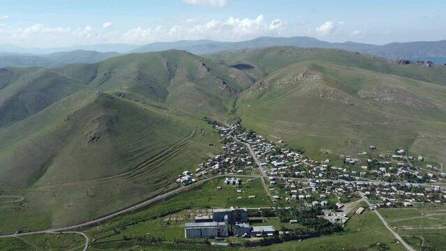 Drone footage soars above a quaint town nestled in Armenia's mountainous regions, capturing the harmonious blend of urban life and nature's grandeur.