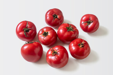 Few ripe red tomatoes on a light background