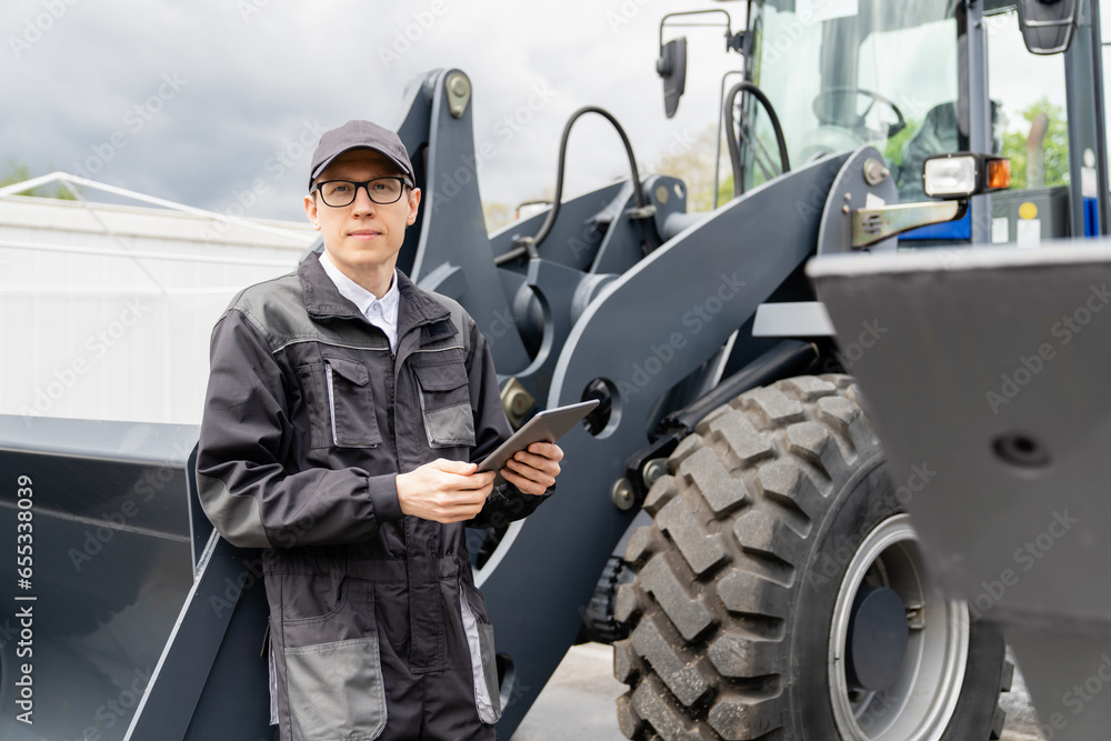 Aufkleber serviceman with digital tablet on a background of the tractor.