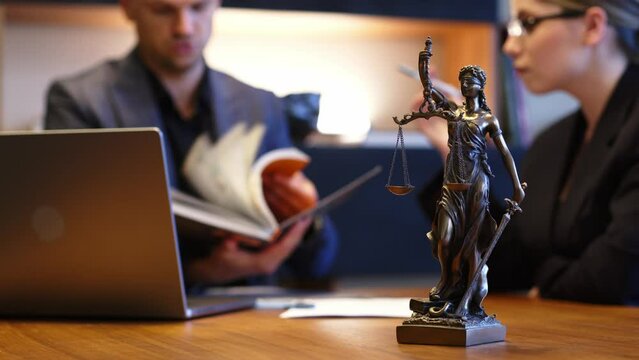 A lawyer meets with a new client. A young male lawyer in a suit sits at an office desk, shares legal advice, explains the inheritance process, tries to help. Legal advice concept