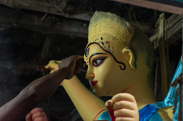 An artisan drawing eyes of idol of goddess Durga