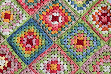 Colorful granny squares Crochet pattern close up photo. Beautiful ornament made of organic cotton yarn. Hobbies and leisure concept. 