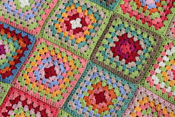 Colorful granny squares Crochet pattern close up photo. Beautiful ornament made of organic cotton yarn. Hobbies and leisure concept. 