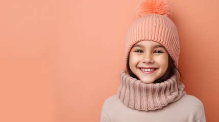 Portrait of a cute little girl in a knitted hat on a color background