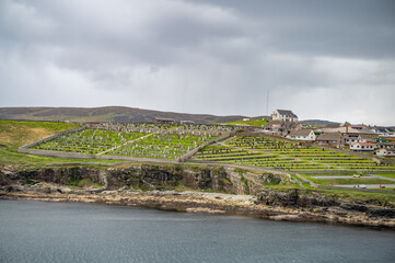 Shetland Islands Cityscape and old graveyard with sea in front, wide angle shot, view from the distance, Scotland