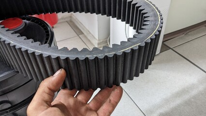 timing belt for large industrial machinery in a man's hand